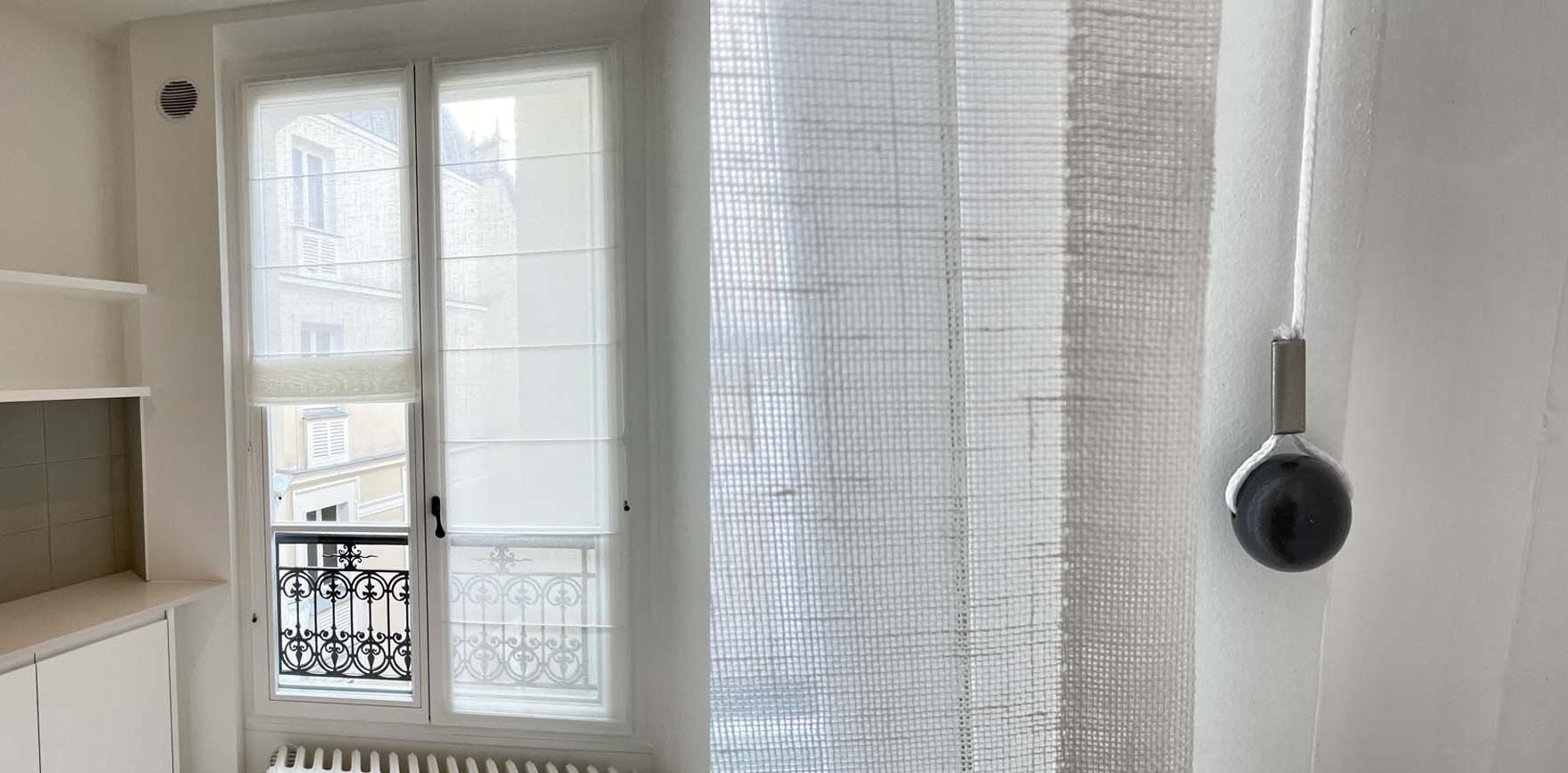 La fenêtre de la cuisine est habillée de stores en voile de lin avec nos accessoires Pampilles.